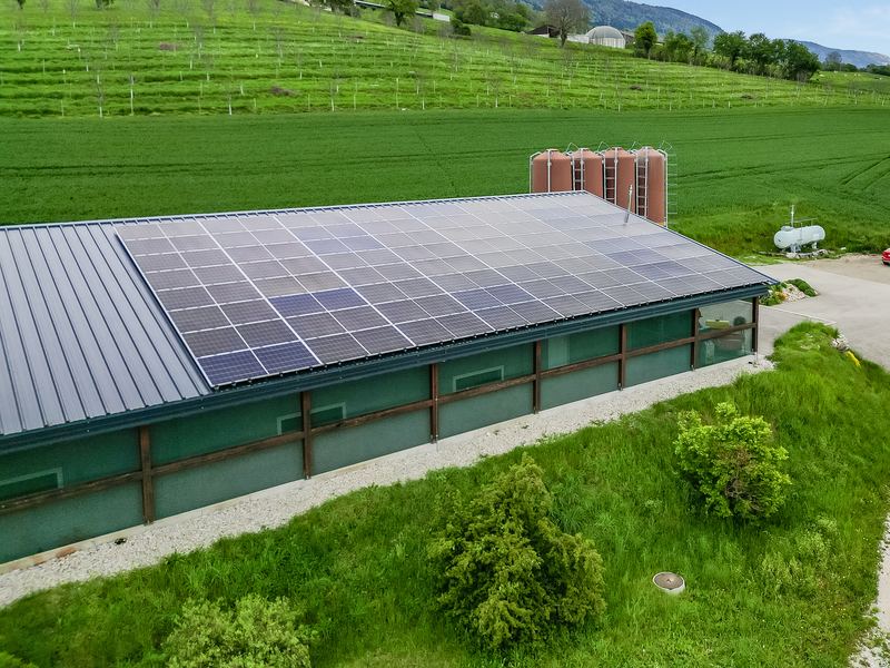 Farm building with a rooftop solar array near Epalinges, Switzerland